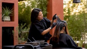 Hair colorist applying corrective hair color in salon